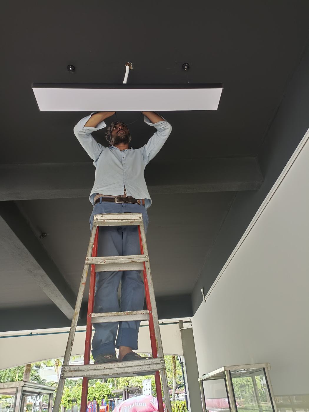 Installing a ceiling light on a ladder